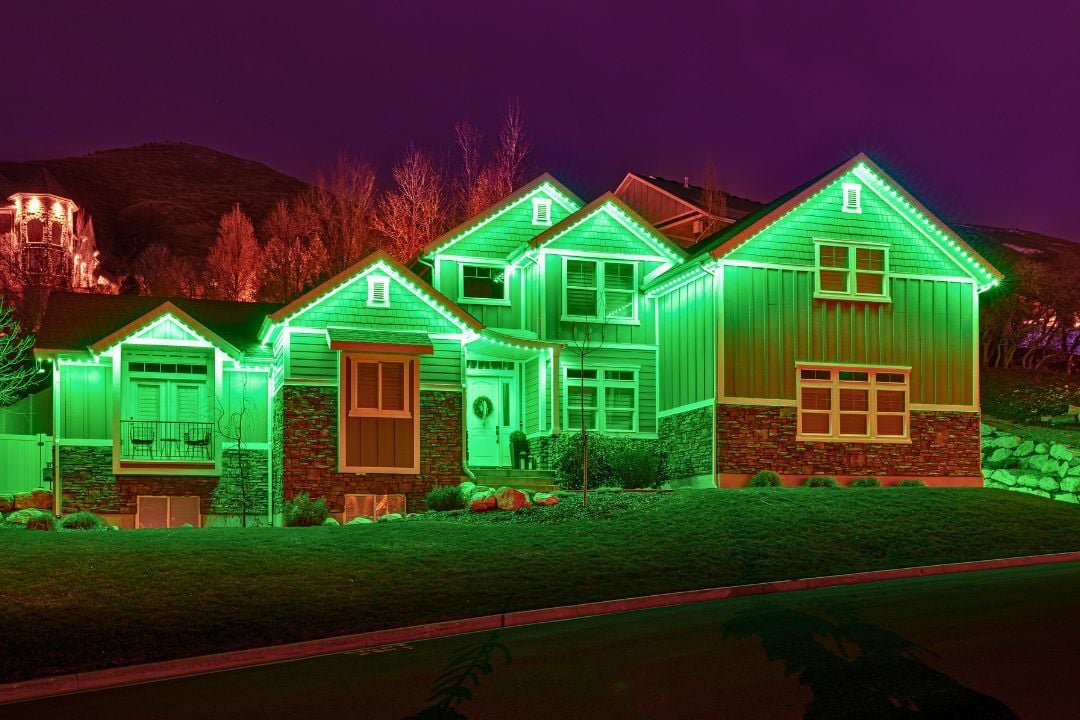 A picture of a home with a green light splash on the home.