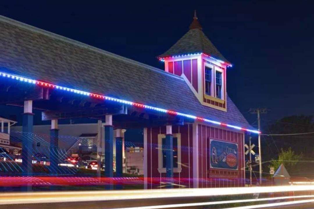 a train station that has red, white and blue Trimlight Lighting