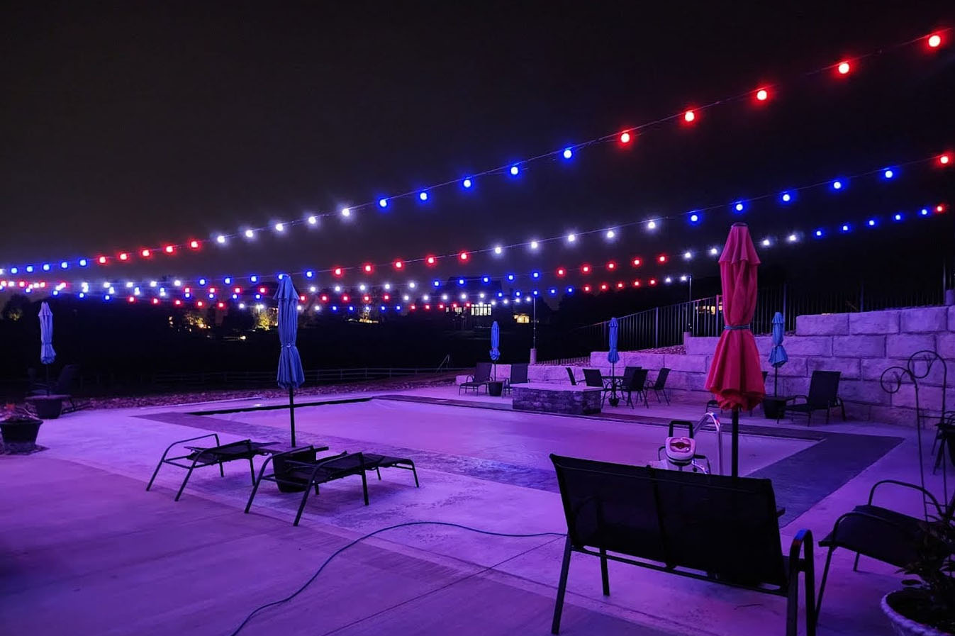 Red, white, & blue Trimlight globelights on a patio