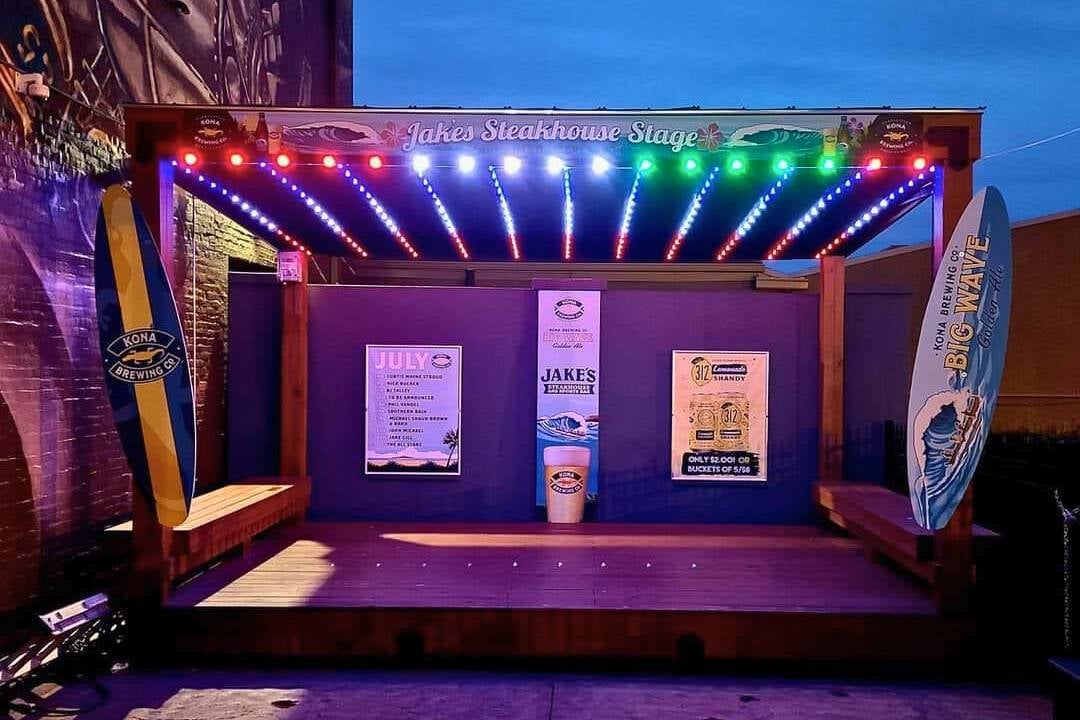 A stage at a restaurant that has green, white and red Trimlight LEDs